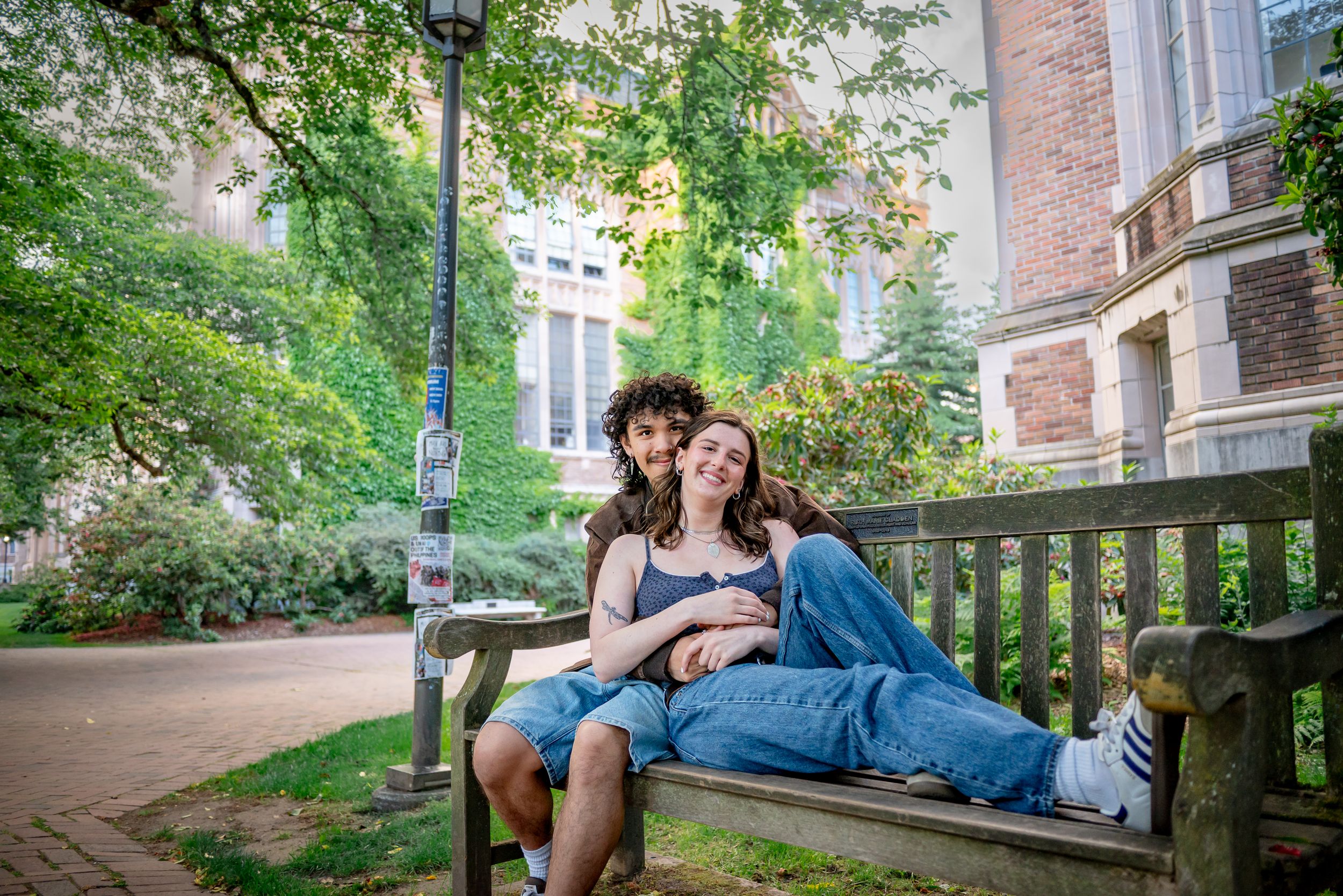 Graduate and boyfriend embracing on a bench in the University of Washington Quad
