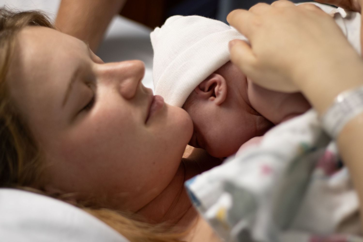 New mother sharing a tender first moment with her newborn baby skin-to-skin.