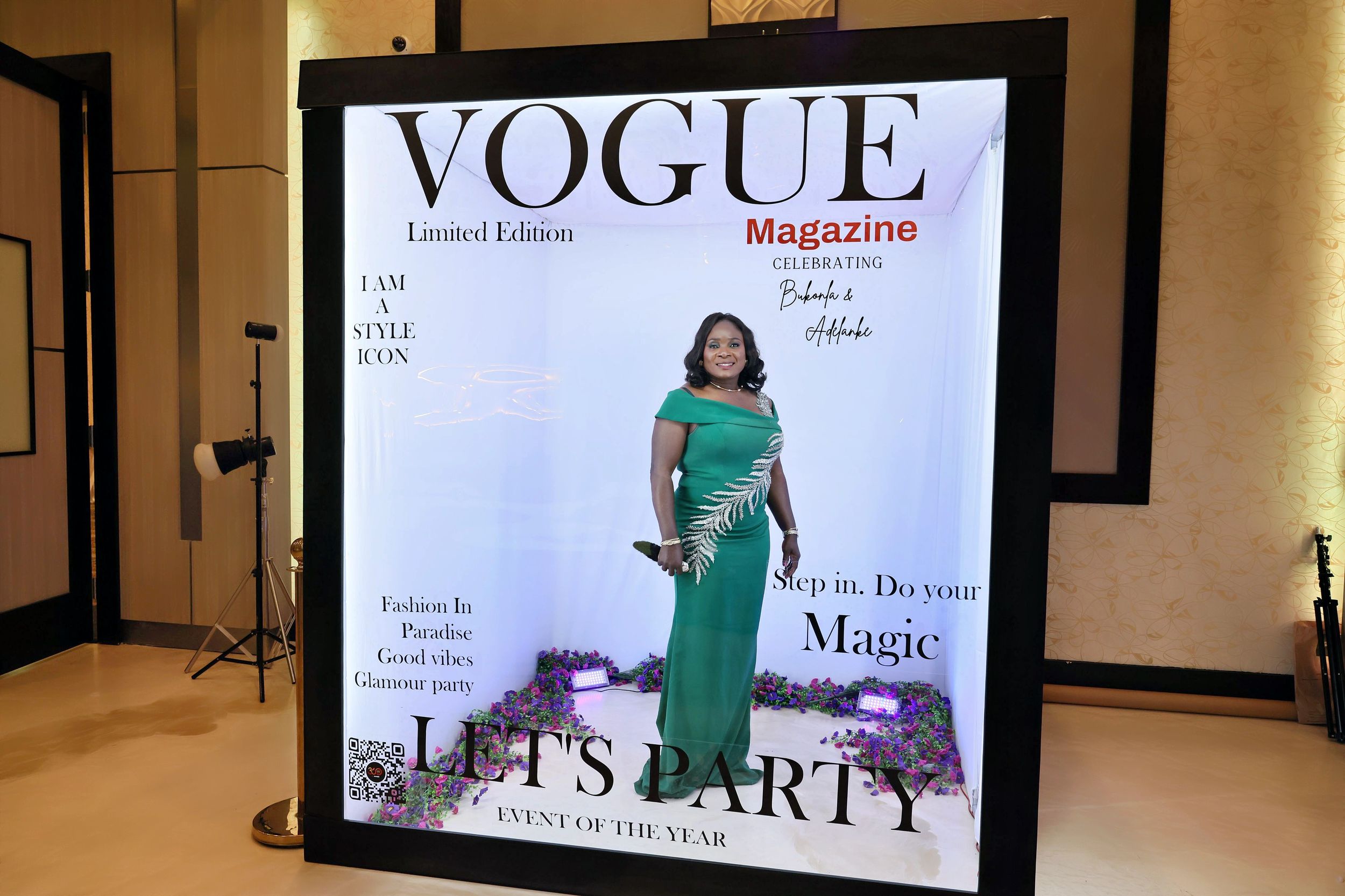 Woman in green gown posing at Vogue Magazine Limited Edition party photo booth.