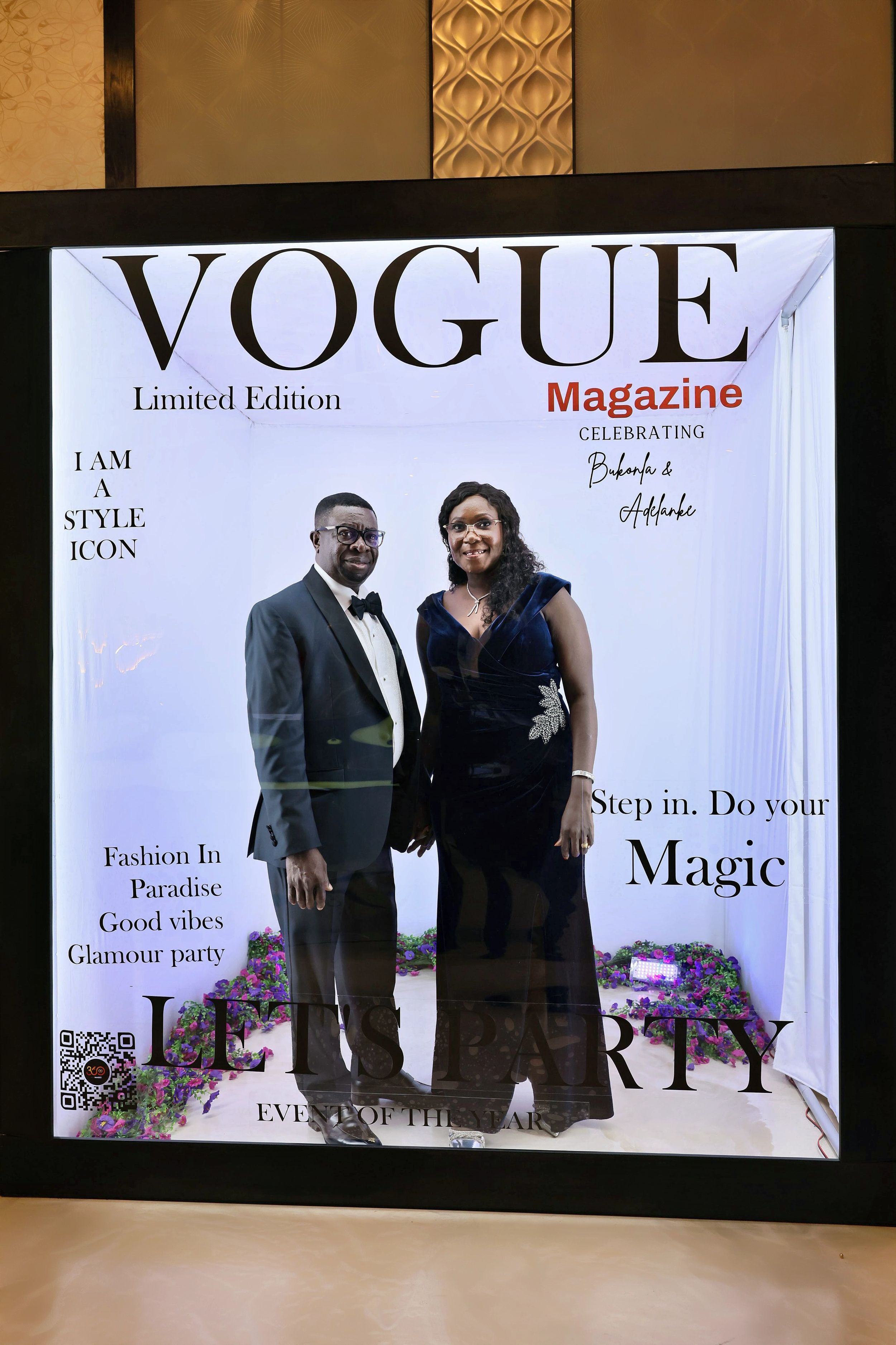 Elegant couple posing together at Vogue Magazine Limited Edition Lets Party photo booth.