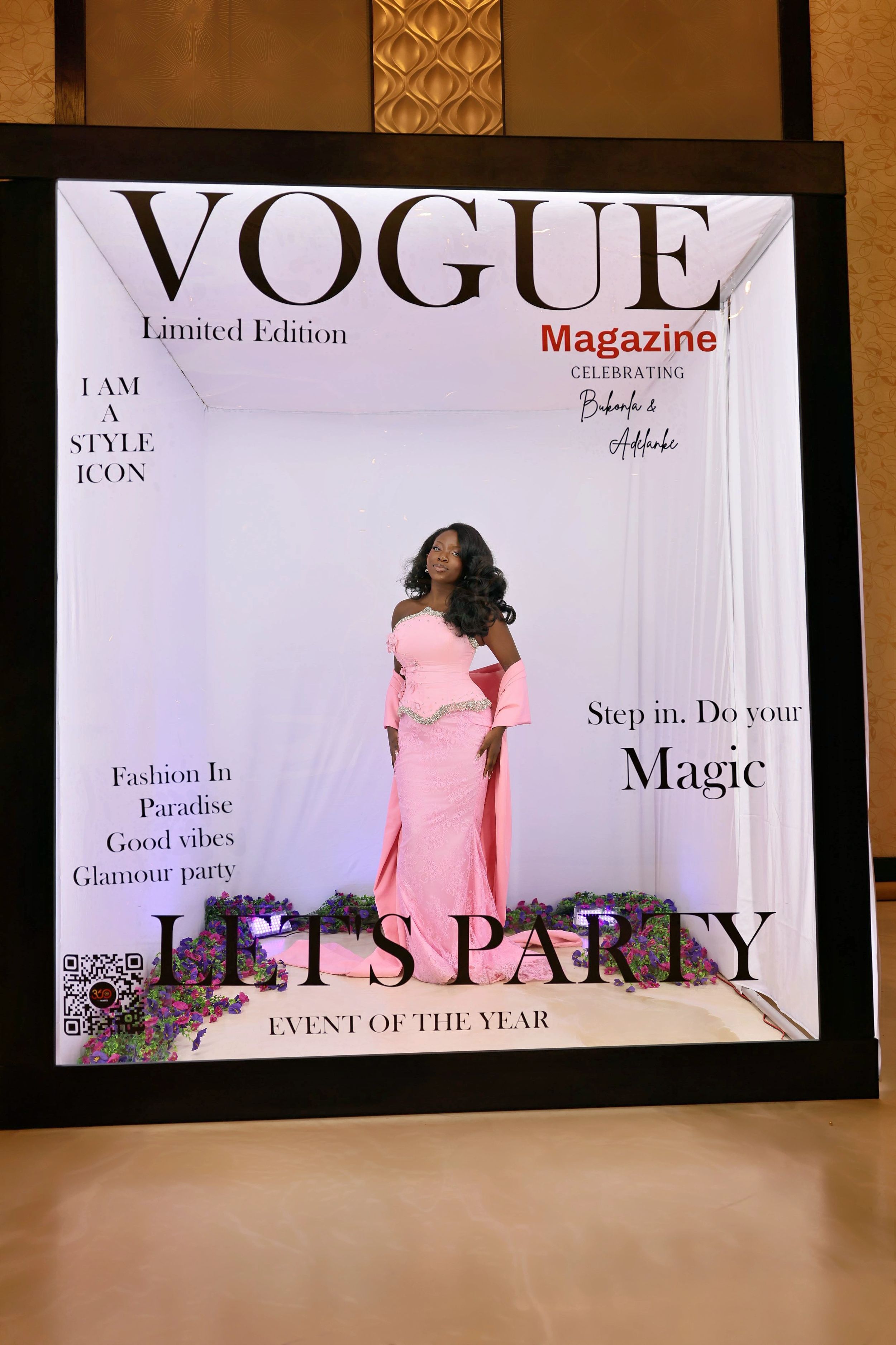 Woman in pink off-shoulder gown at Vogue Magazine Lets Party event photo booth.