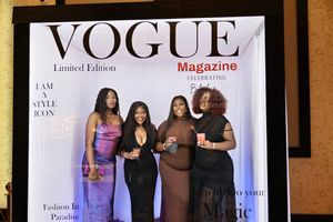 Four women in elegant dresses posing together at Vogue Magazine Limited Edition glamour party event.