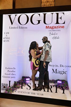 Couple posing playfully in Vogue Magazine Limited Edition photo booth at Let's Party glamour event.
