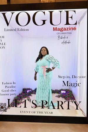 Woman in mint green lace dress posing in Vogue Magazine Limited Edition glamour party photo booth.