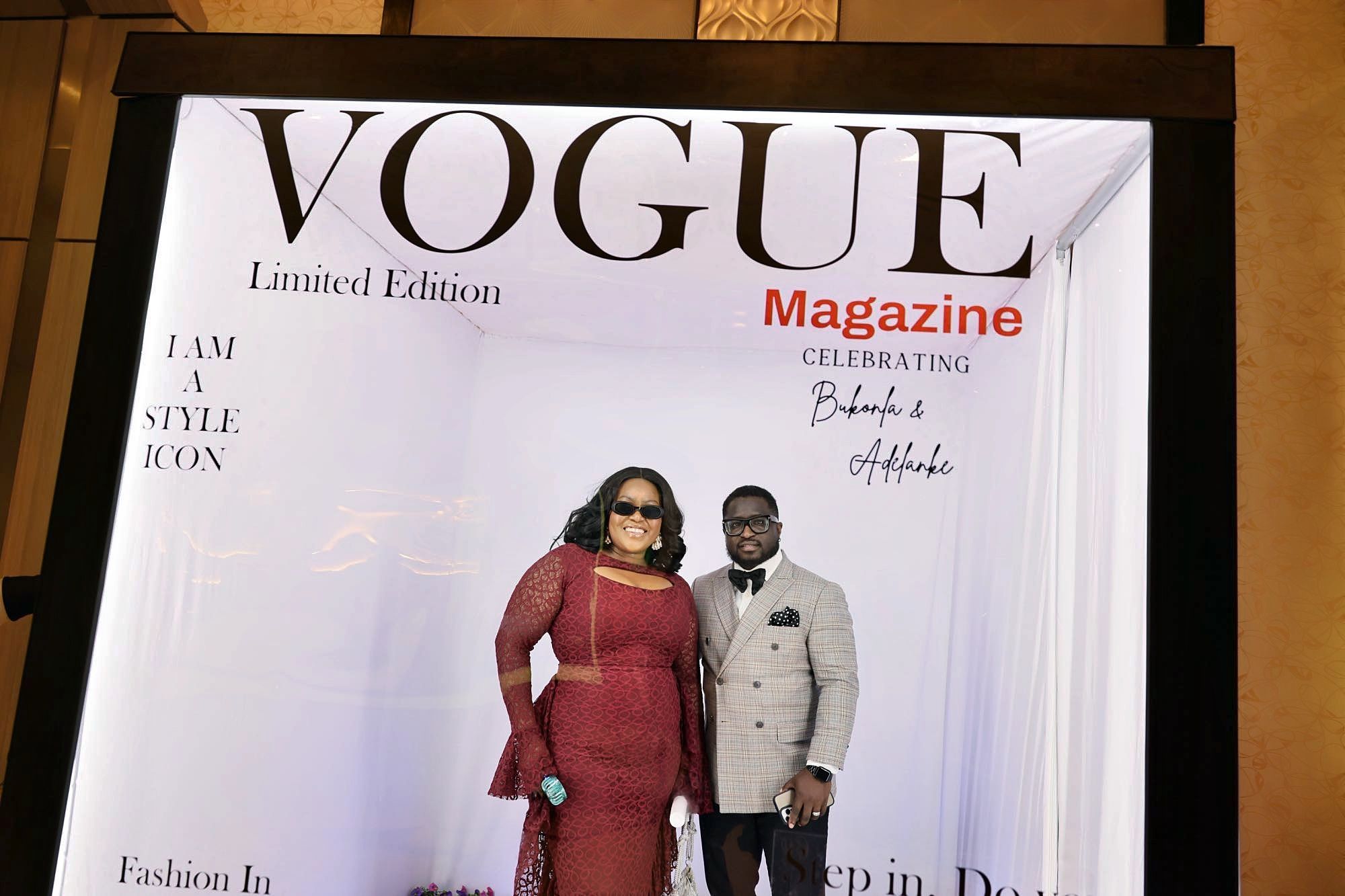 Couple in elegant formal wear posing in Vogue Magazine Limited Edition celebration photo booth display.