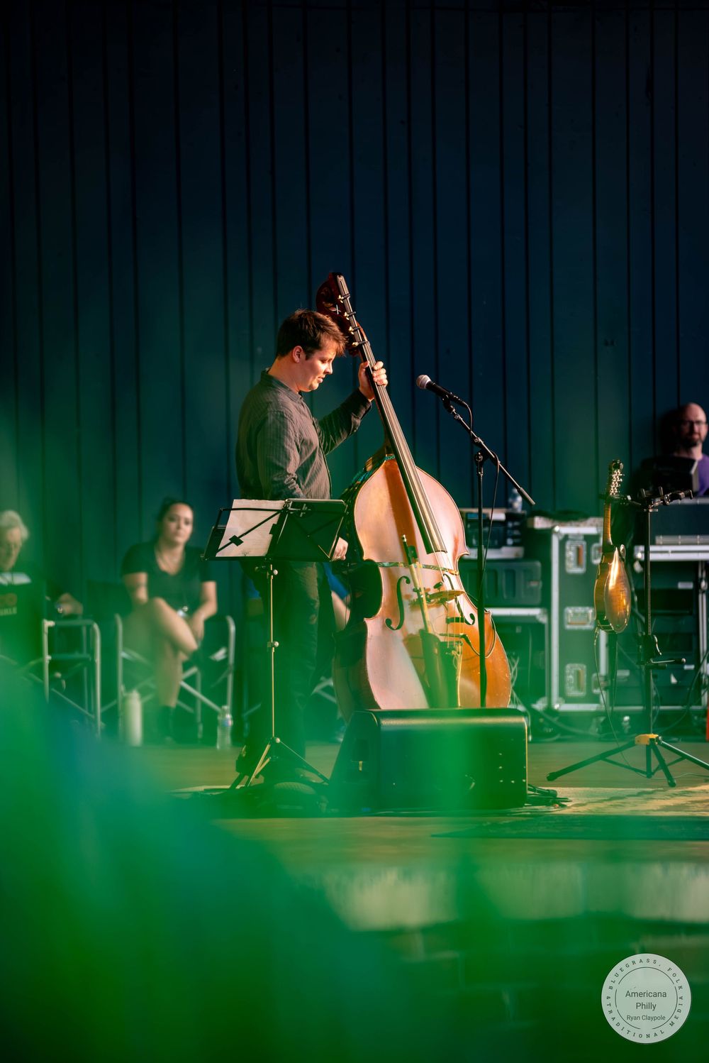 Musician playing a large double bass on stage during a live concert performance.