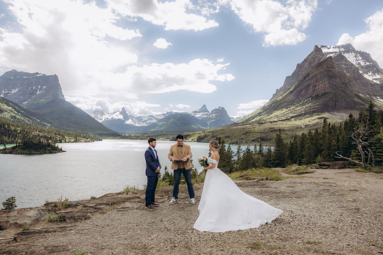 Couple exchanges vows at a scenic mountain elopement beside a turquoise lake in Glacier National Park.