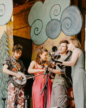 Festival crowd enjoying live music at golden hour in the Colorado mountains.