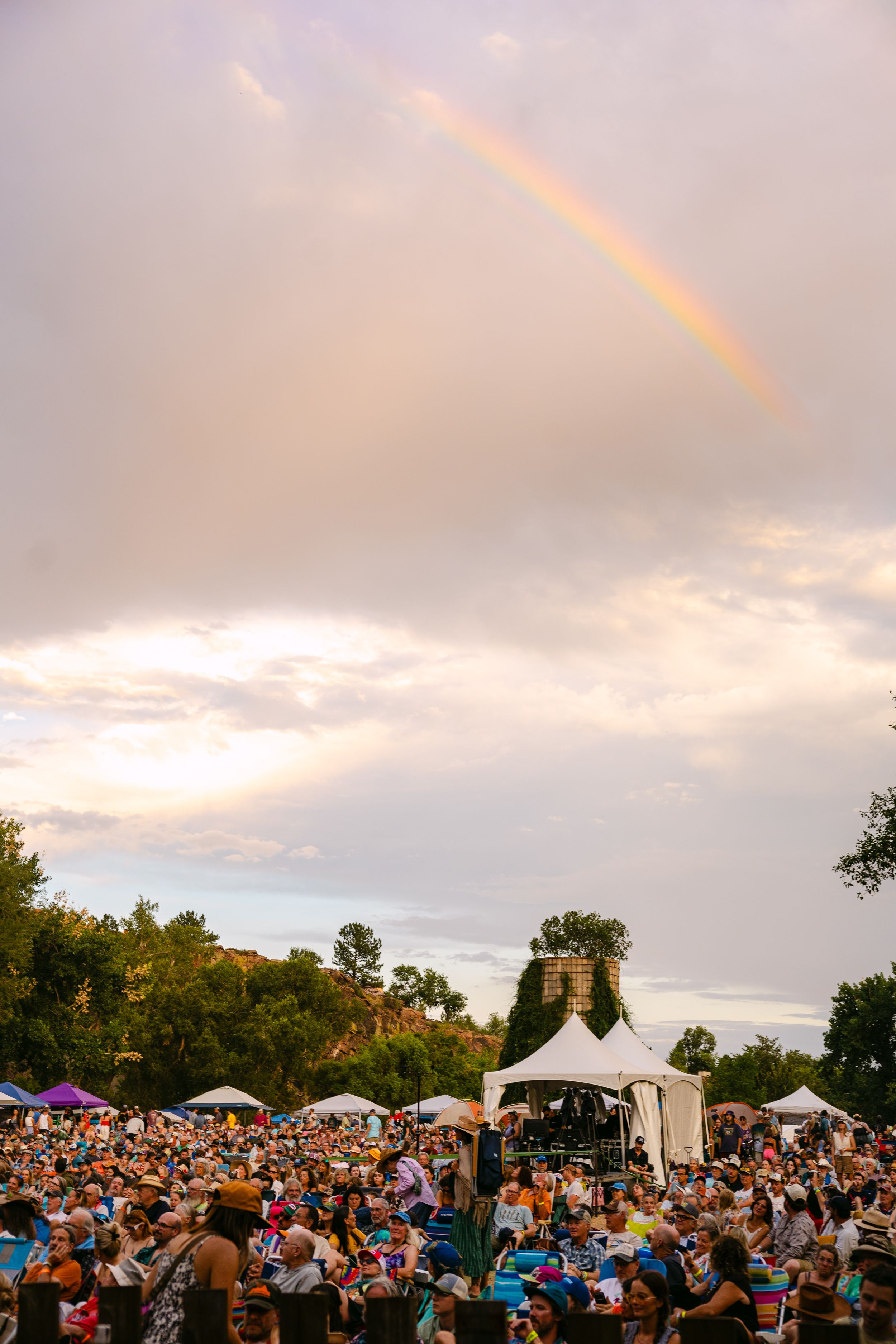 Festival crowd enjoying live music at golden hour in the Colorado mountains.