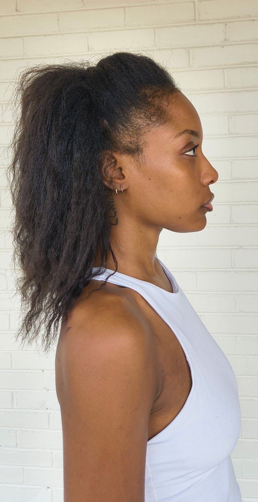 Side (right) profile digital of Genesis Dudley with natural hair, wearing a white tank top.