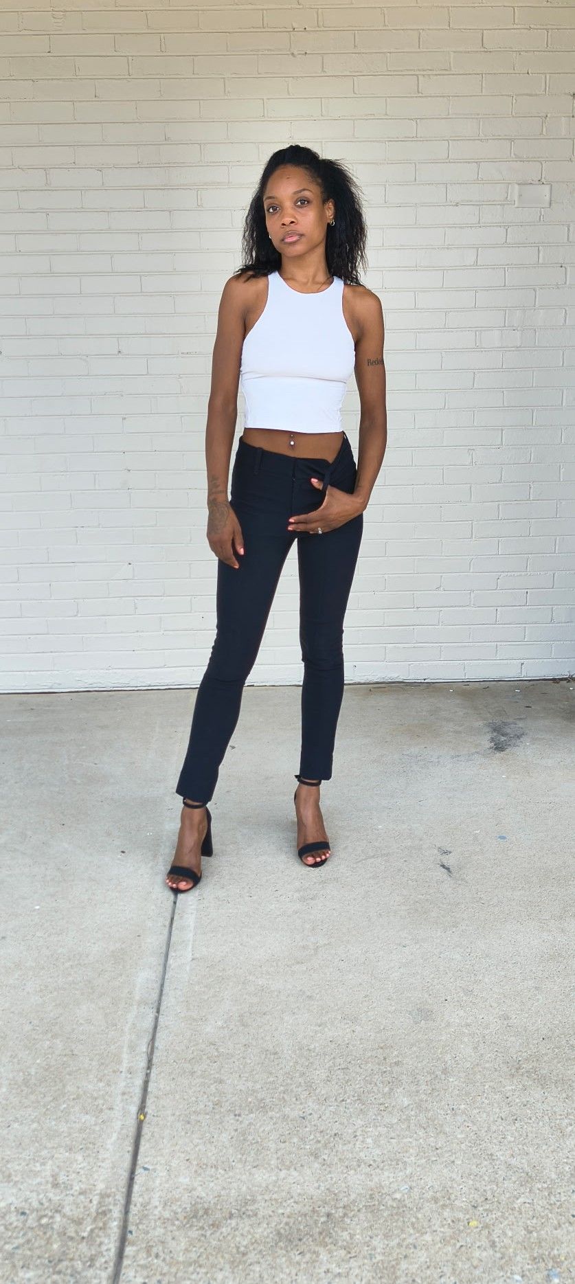 Full-length digital of Genesis Dudley wearing a white tank and black pants.