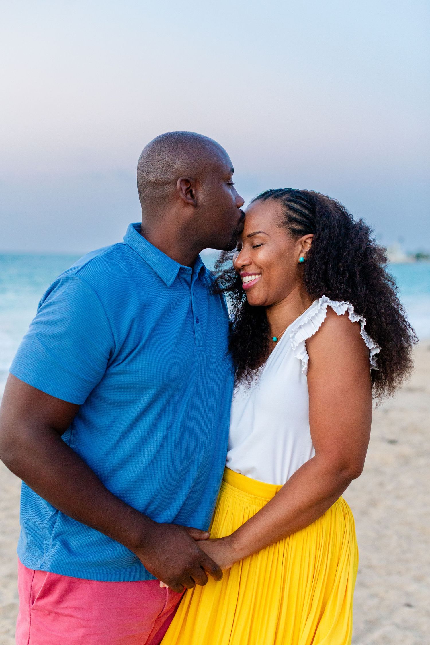 Couples portrait. Husband kissing wife's forehead on the beach in Isla Verde, Carolina, Puerto Rico.