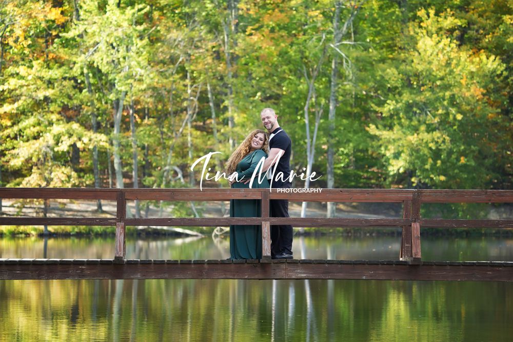 A peaceful autumn scene with a wooden bridge reflected in still waters surrounded by yellow leaves.