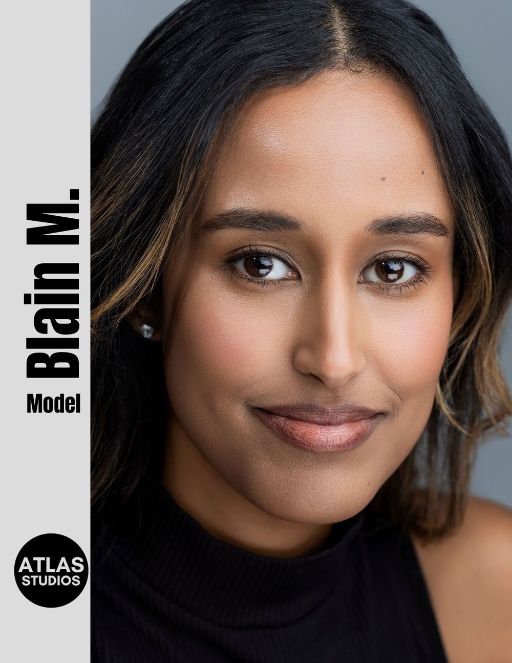 Professional headshot of model Blain M. smiling warmly, photographed by Atlas Studios against a gray background.