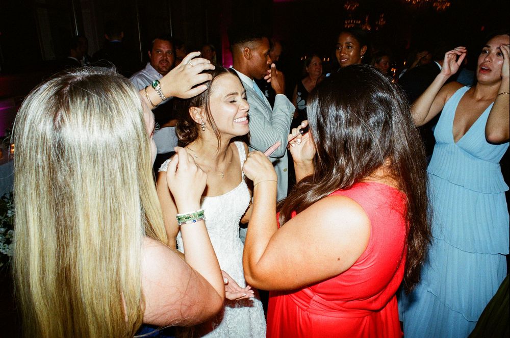 Guests dancing and celebrating at a lively wedding reception party indoors.