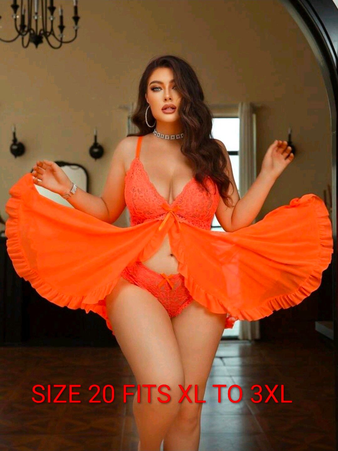 Woman in orange lace lingerie set with flowing skirt, size 20 fits XL to 3XL, posing indoors.