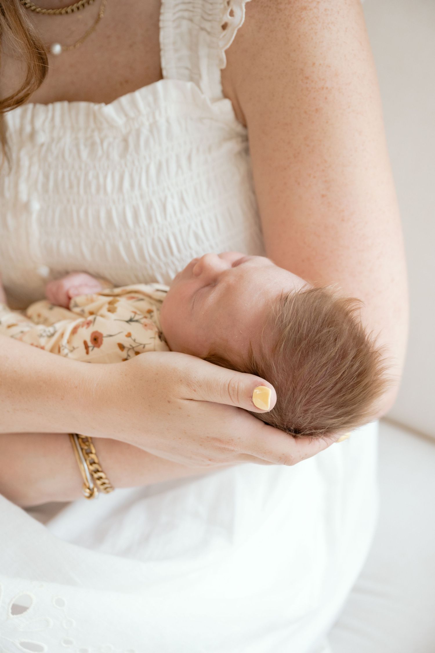 mom cradles newborn baby's head during an in home newborn session with Jagger Rose Photography in Minnetonka, MN.