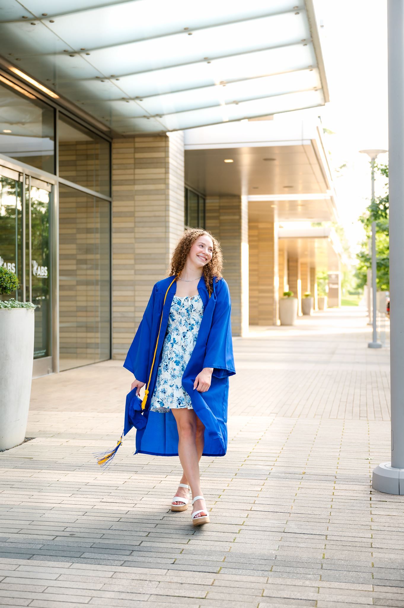 High school senior girl in Spring, Tx wearing a blue graduation cap and gown.