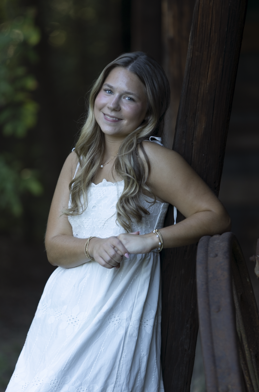 Two flower girls in white tulle dresses with wicker baskets pose in a church aisle during a wedding ceremony.