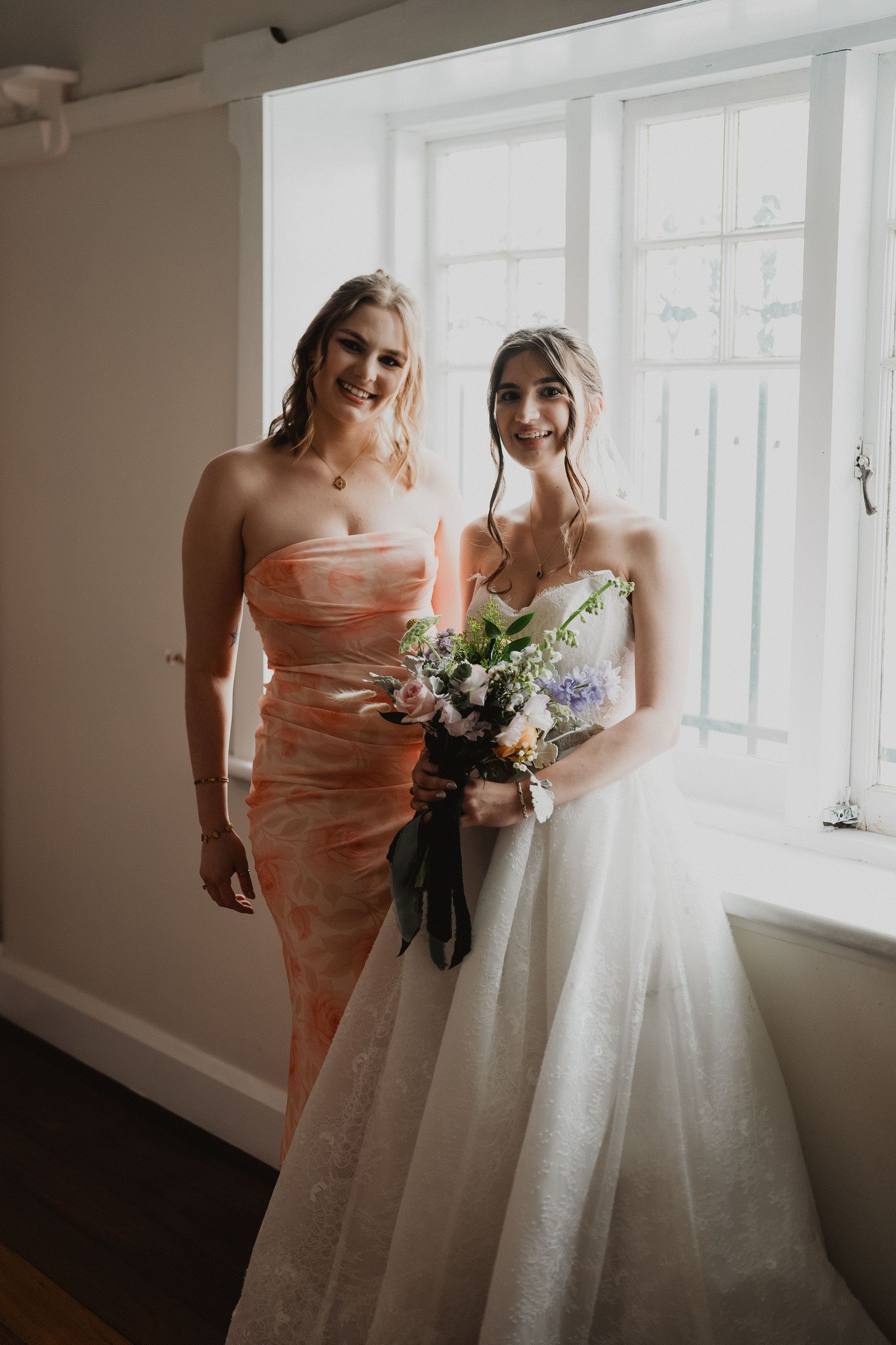 Ella and her bridesmaid getting ready by the window