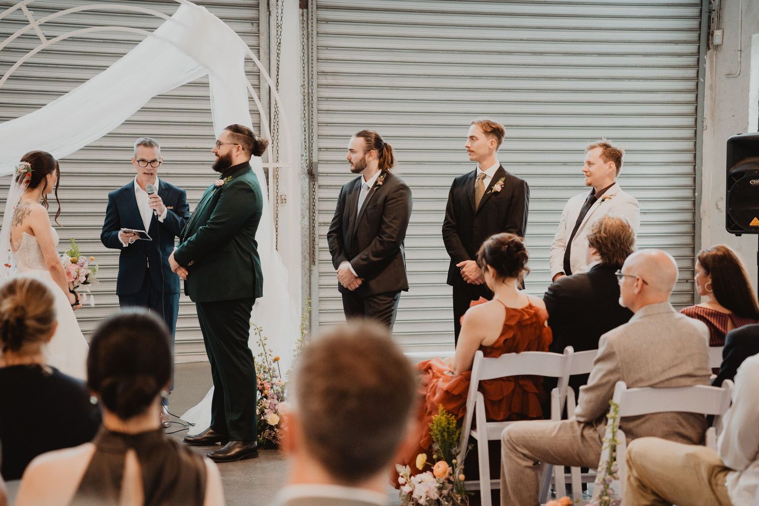Harrison and Ella's wedding ceremony with guests looking on