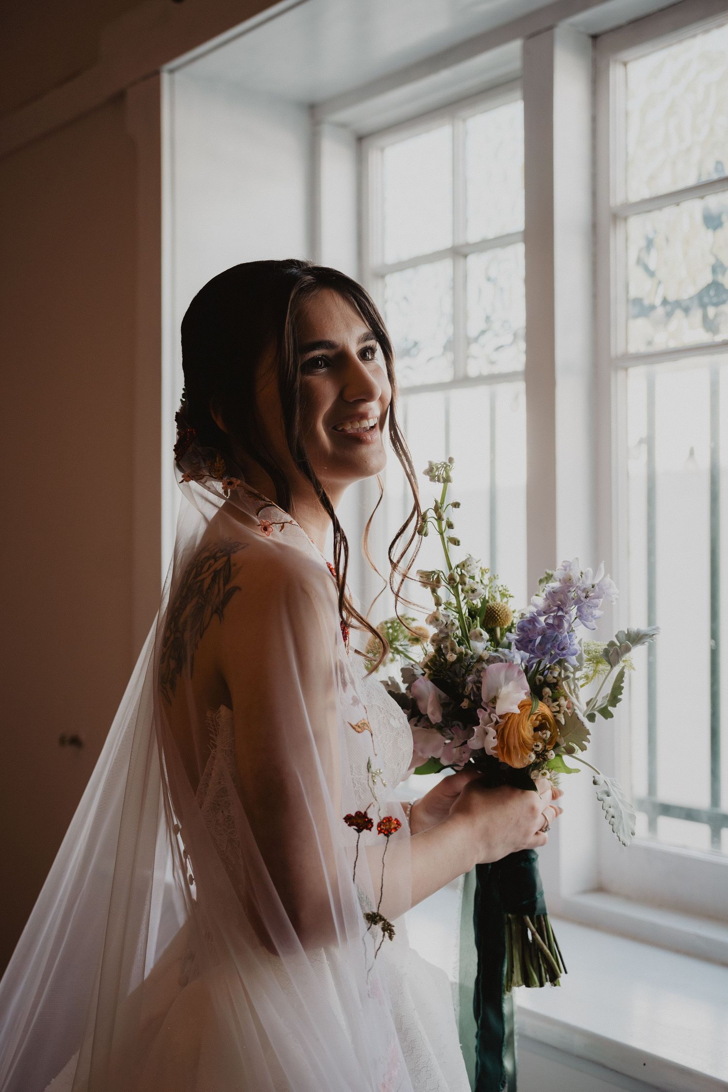 Ella holding her bouquet by the window