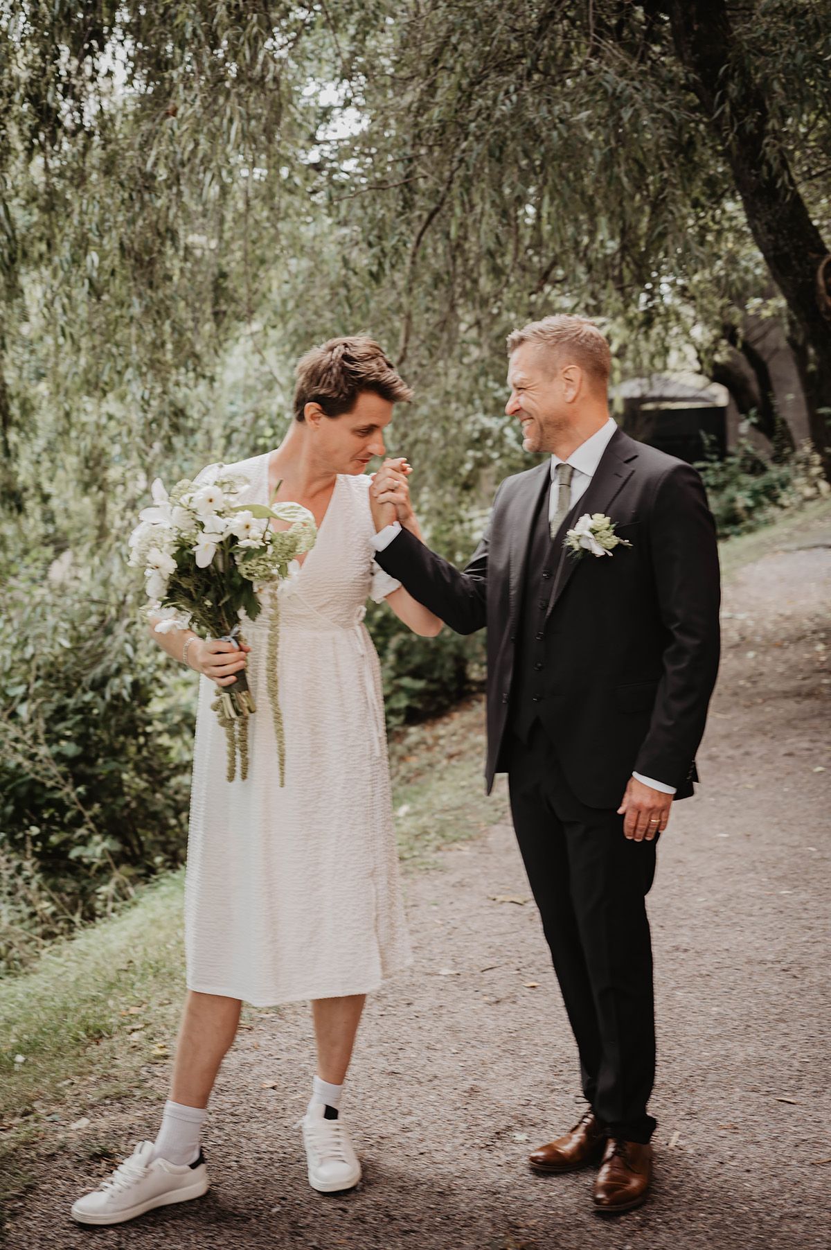 First look-fotogring i Norrköping, brudgummens vän är utklädd till brud och kysser brudgummens hand.