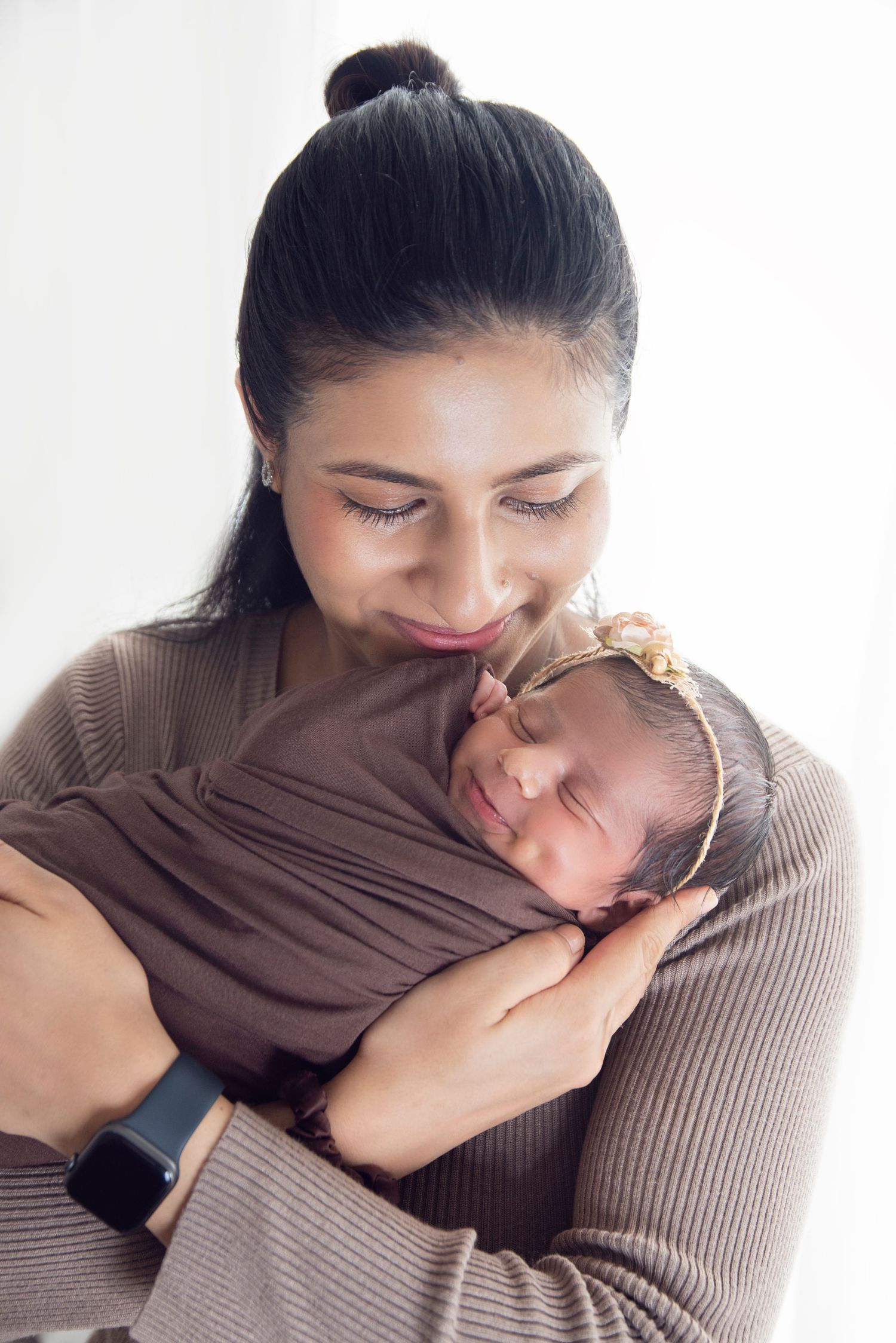 mother holding her 9 days old newborn baby girl