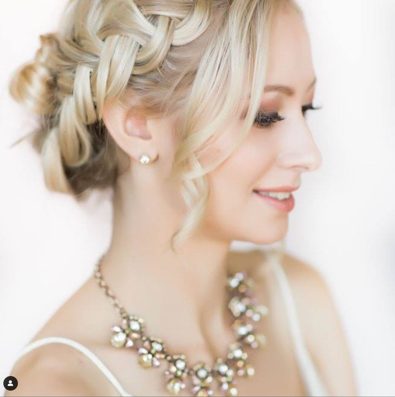 Soft bridal portrait showcasing elegant updo hairstyle and crystal statement necklace.