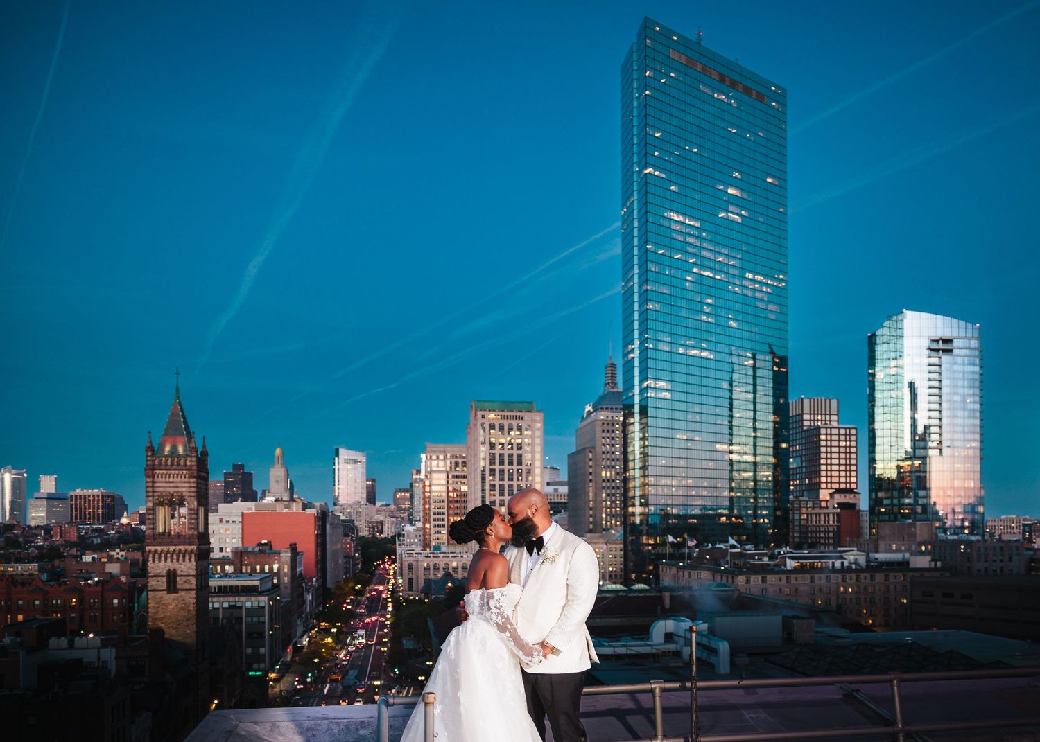 The bride and groom share a passionate kiss atop the roof of the Hotel Lenox in Boston. Boston Wedding Photographer.
