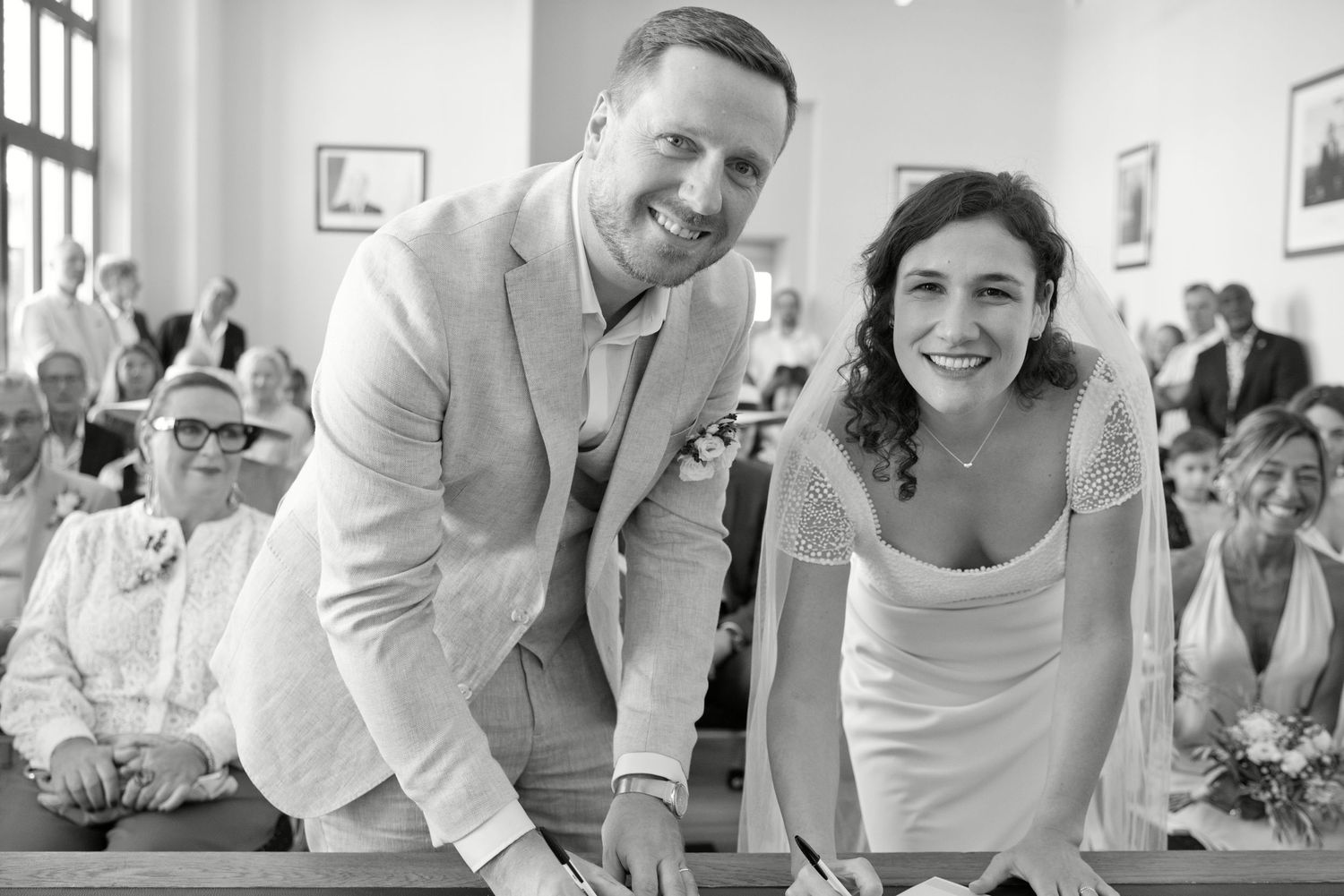 Augustine et Ugo sourient au moment des signatures de leur mariage civil.