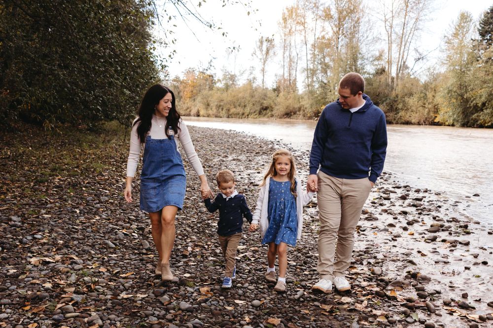 Family walking by river during fall photo session in Washington