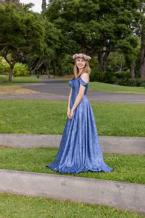 High school senior with blue dress and head lei flower crown at Seabury Hall on Maui