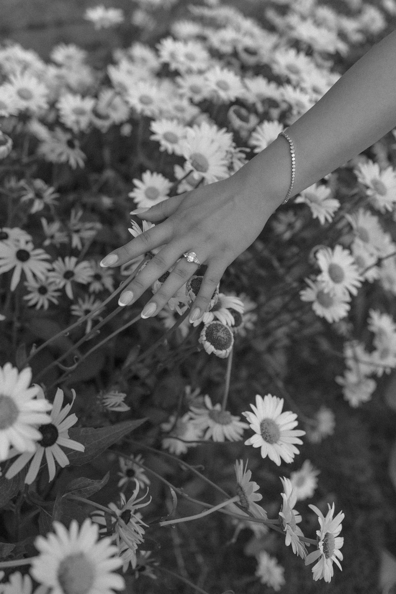 Black and white photo of a large decorative dice with floral arrangements in an industrial space.