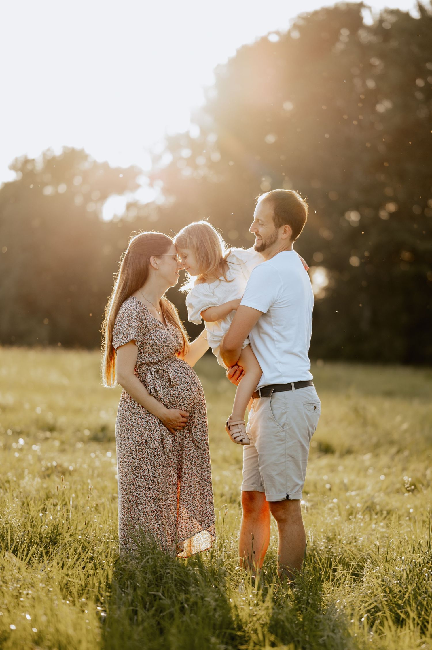 Familielbild im Gras stehend, Kind küsst Mama auf die Nase im Sonnenuntergang, Jovanna Burkard KWICKSHOT Bad Saulgau