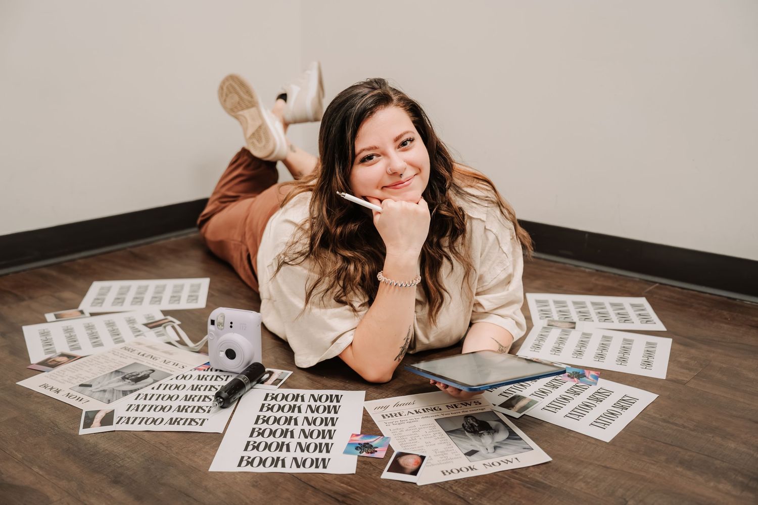 Woman smiling on floor surrounded by newspapers and marketing materials, promoting Door Now brand.