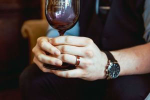 Storytelling wedding Photo of a groom holding a Morris Jewelry wine glass after Downtown Bowling Green, Kentucky elopement