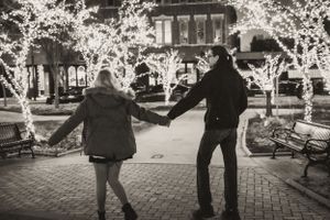 Storytelling photo of a couple under the Christmas lights in downtown Bowling Green, Kentucky