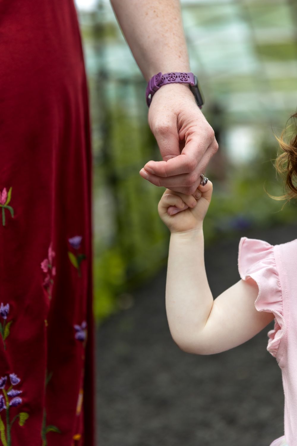 A sequence of frames showing someone holding a small child's arm in front of red curtains.