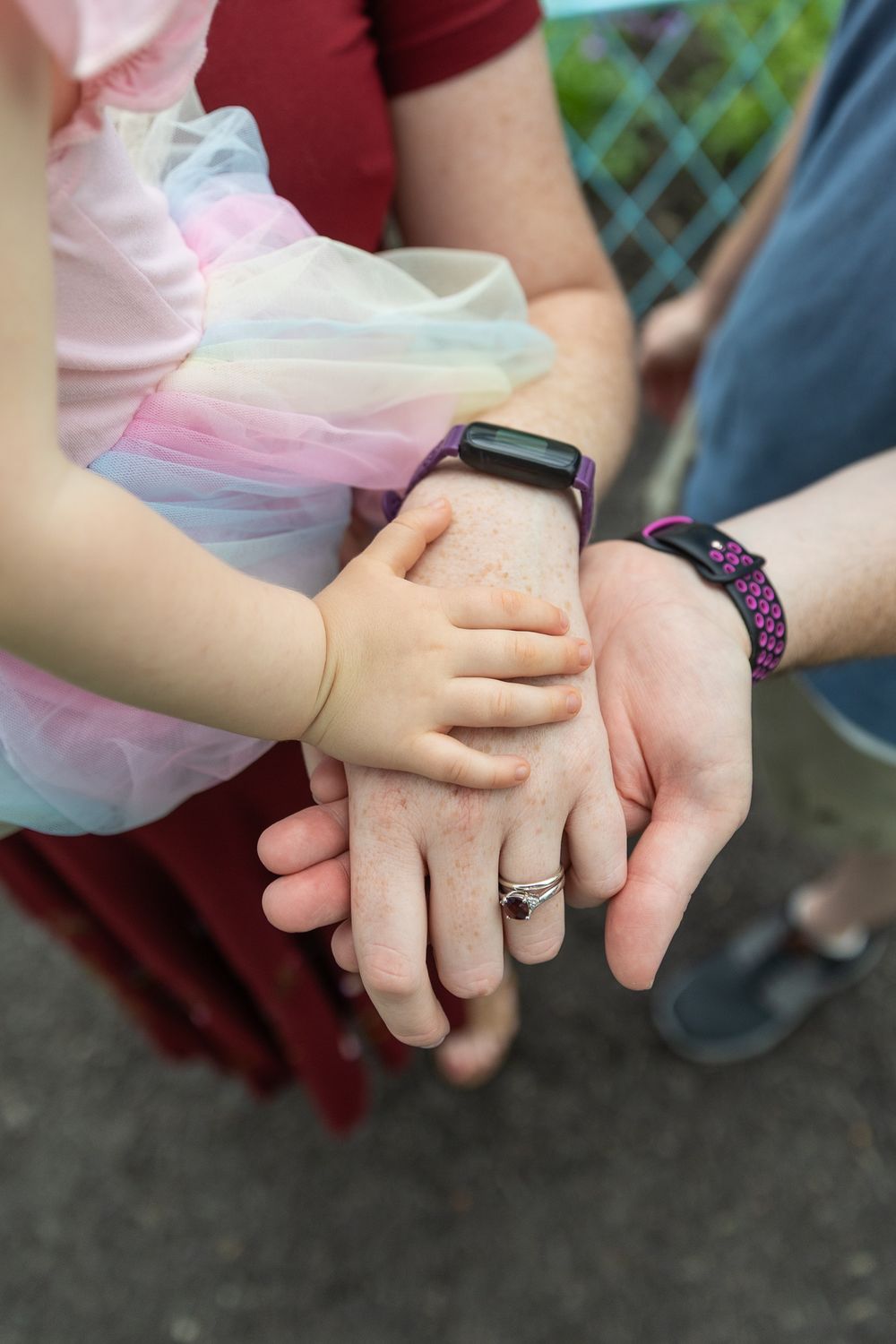 Closeup series of hands holding each other showing affection and togetherness with a pink and burgundy color theme.