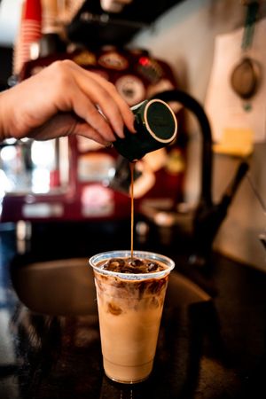 Coffee being poured into a cup of iced latte, creating a beautiful layered effect viewed from five different angles.