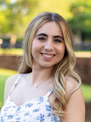 Outdoor portrait featuring someone in a floral dress with natural bokeh background.