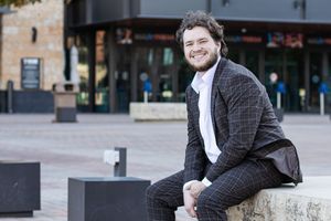 Professional wearing a gray suit jacket poses outdoors against an urban backdrop in multiple candid shots.