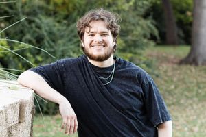 A person in a black t-shirt poses outdoors in a series of casual portraits with trees in the background.