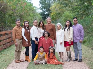 Extended family group portrait on rustic wooden bridge path during autumn.