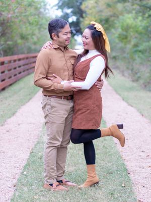Couple in casual fall outfits sharing playful moment on dirt path.