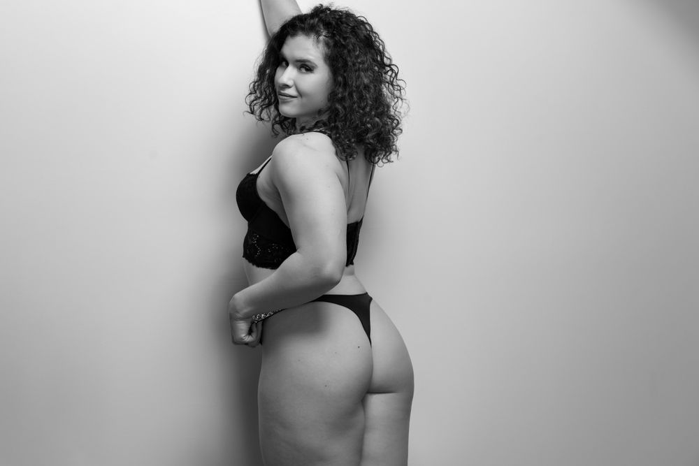 Black and white boudoir photo showing person in lingerie from behind.