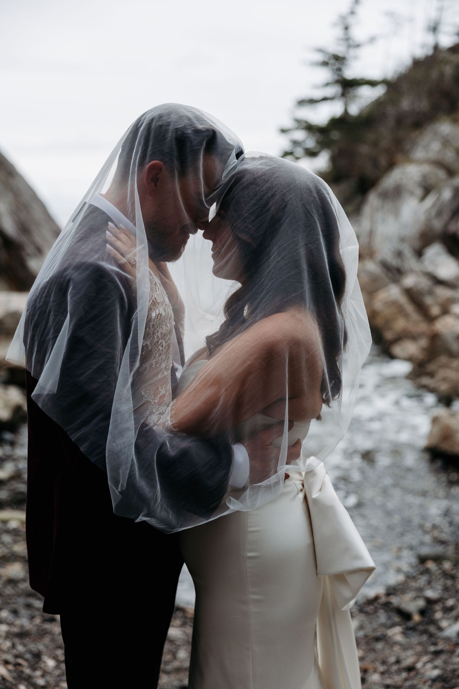 A romantic wedding couple shares intimate moments under a veil in a series of four artistic photographs.