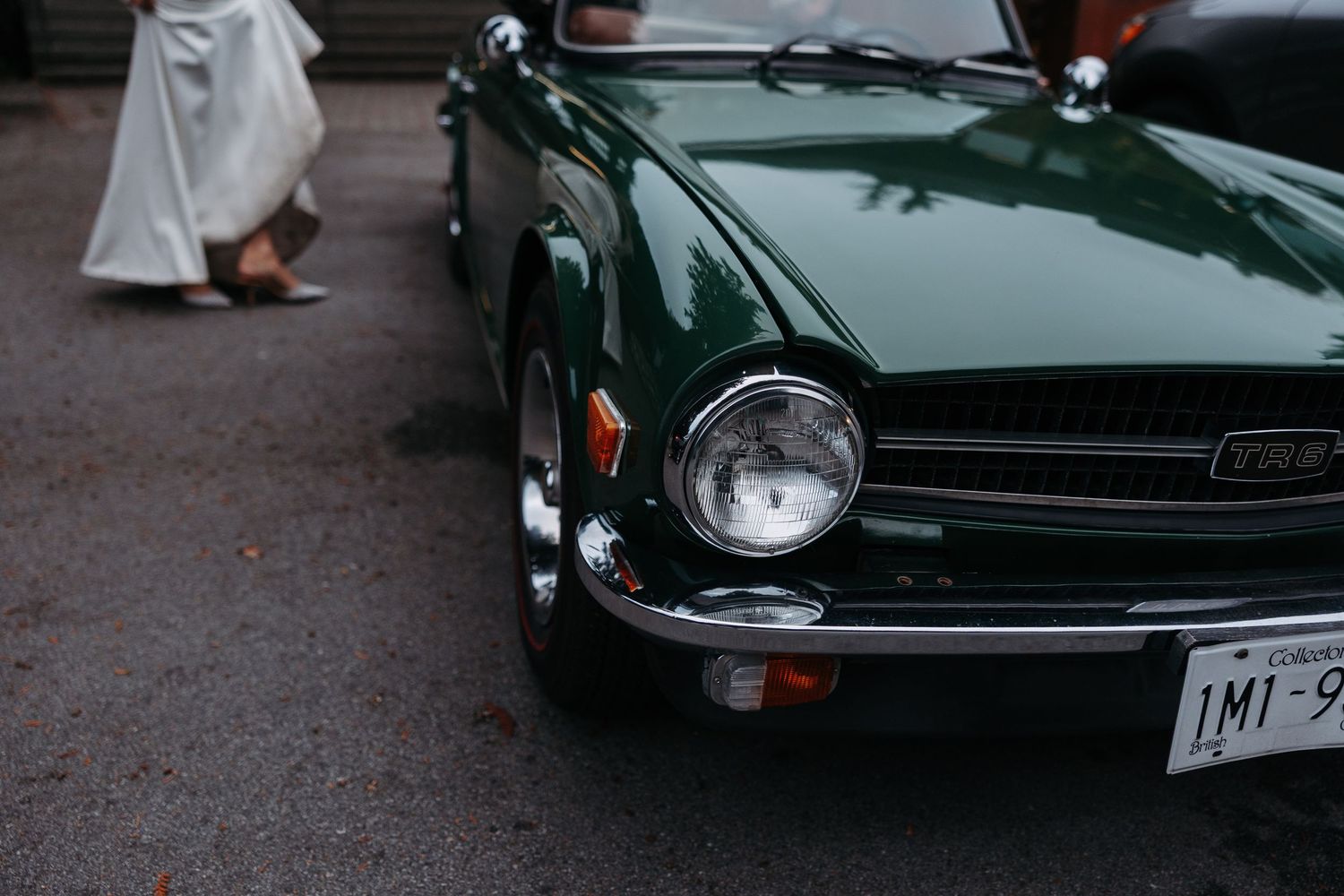 Classic green vintage sports car parked on street with chrome details.