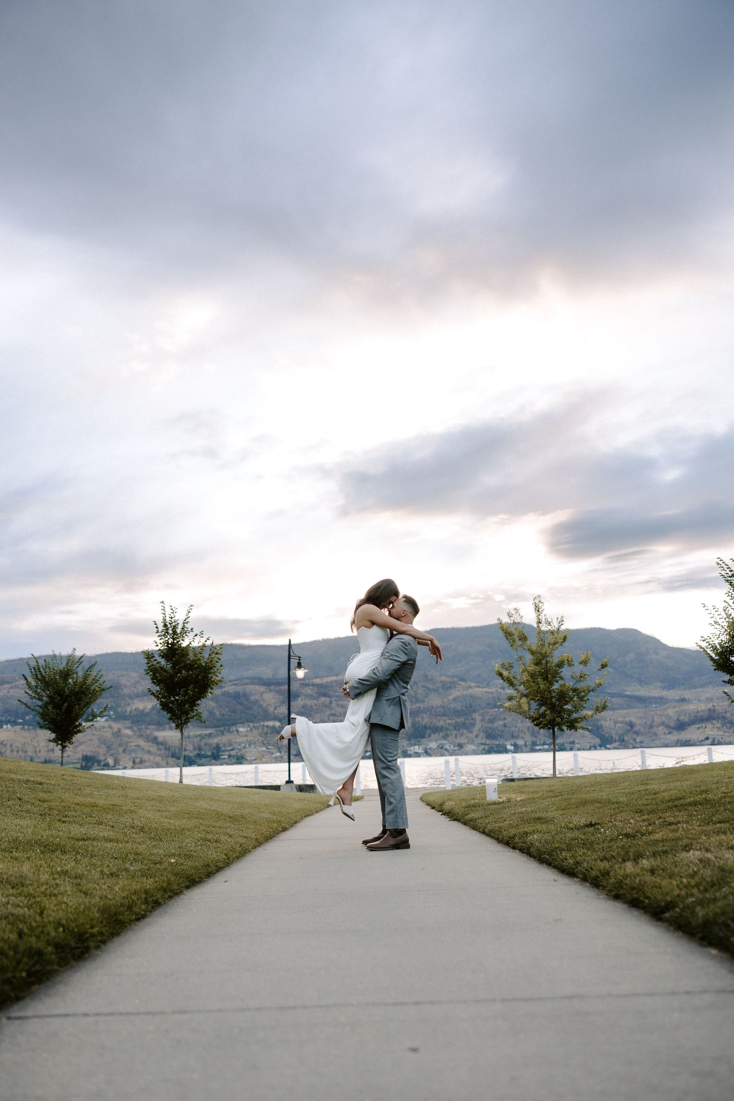 A sequence of someone skateboarding down a path with mountains and cloudy skies in the scenic backdrop.